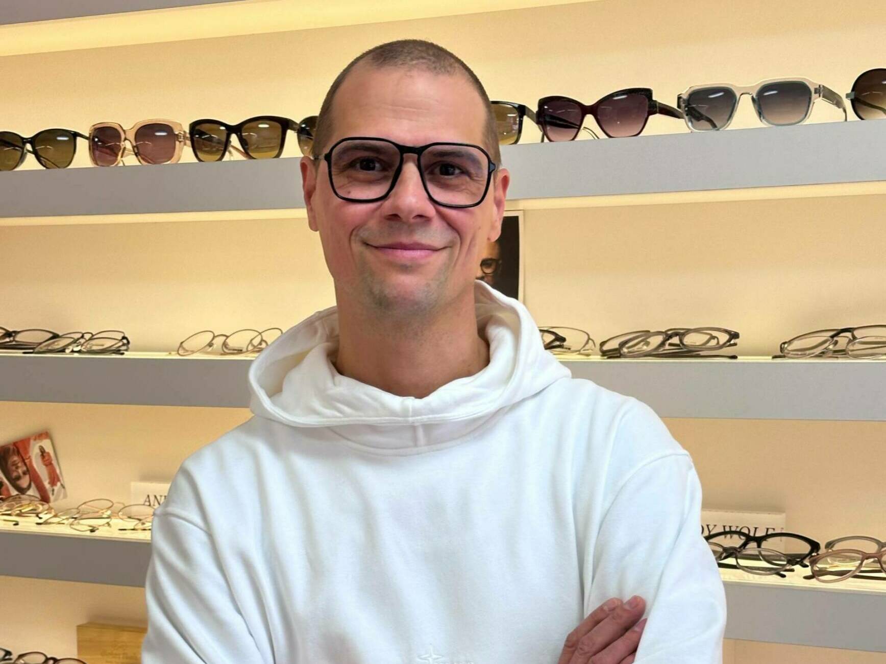 Guido Hehn mit Brille vor Sonnenbrillen-Auswahl bei Optik Hehn Mönchengladbach